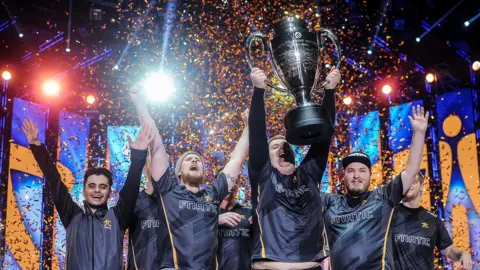 E-sports Team Lifting a Trophy
